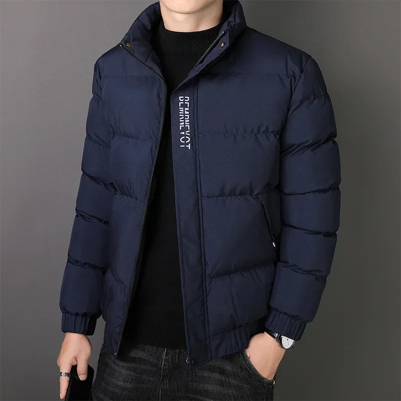 Jaqueta Masculina Nordic em fundo branco, modelo apresentado nas cores cinza, azul e preto. Jaqueta térmica com mangas longas, confeccionada em poliéster resistente e confortável, ideal para o inverno 2025. Design moderno com bolsos frontais e corte ajustado, disponível nos tamanhos P ao G1. Casaco masculino para adultos, estilo urbano e casual.